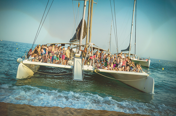 Katamaran legt am Strand von Lloret an